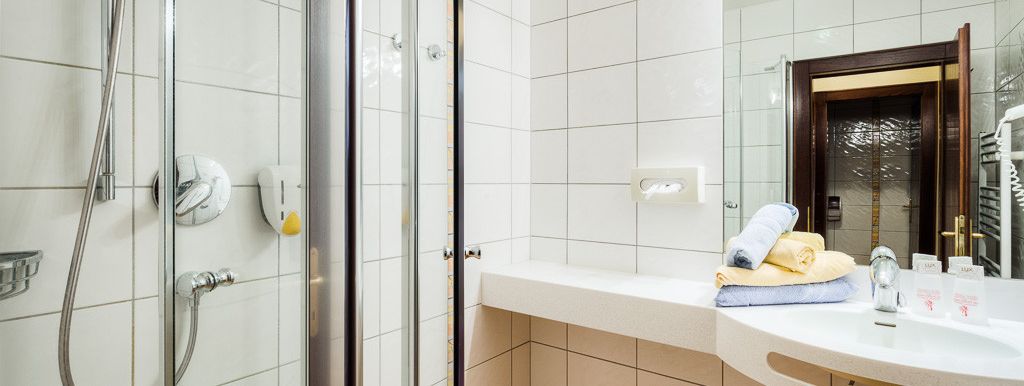 moderne Badezimmer Ausstattung mit Föhn, automatische Wasserhähne, Duschgel, Handtuchtrockner