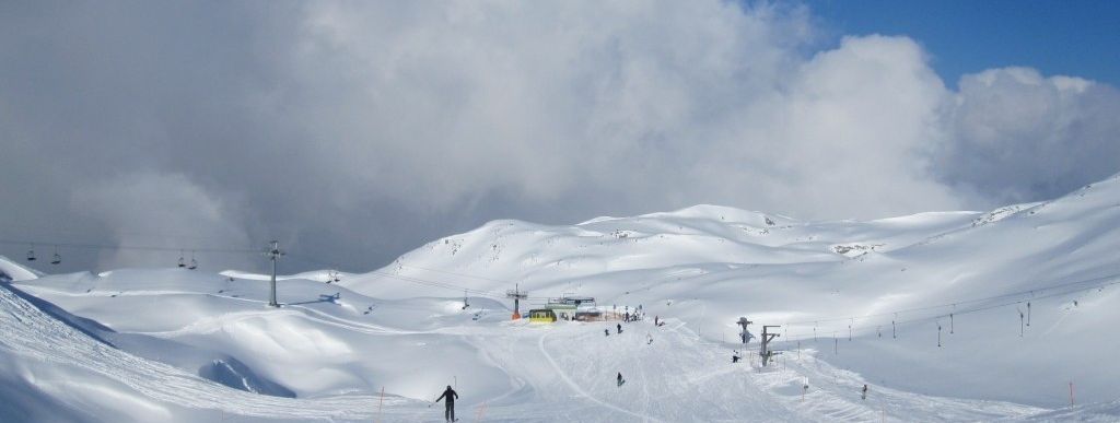 Unterer Teil der kurzen blauen Abfahrt von der Bergstation zu Übungslift und Sessellift.