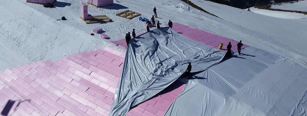 In Kitzbühel wird das Schneedepot zunächst mit Hartschaumplatten und Folie abgedeckt.
