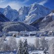 So lässt sich der Winter genießen - verschneite Wipfel und Dächer und die Berge im Hintergrund.