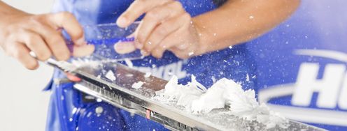 Das überschüssige Wachs wird mit der Kunststoff-Abziehklinge entfernt.