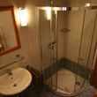Badzimmer mit Dusche, Waschbecken und Toilette