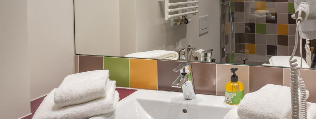 Badezimmer mit Dusche, WC, Ablageflächen und Föhn