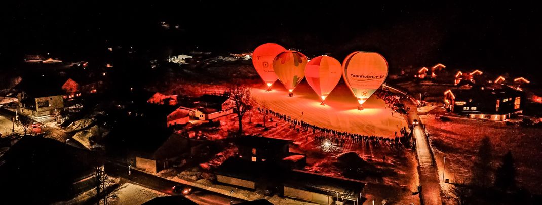 Leuchtende Ballons vor nächtlicher Bergkulisse – beim Ballonglühen im Tannheimer Tal wird der Winterhimmel zur funkelnden Bühne.