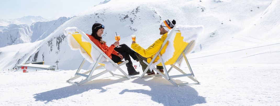 Im Liegestuhl entspannen und beim Aperitif die traumhafte Aussicht genießen - so entspannt geht Winterurlaub in Serfaus-Fiss-Ladis.