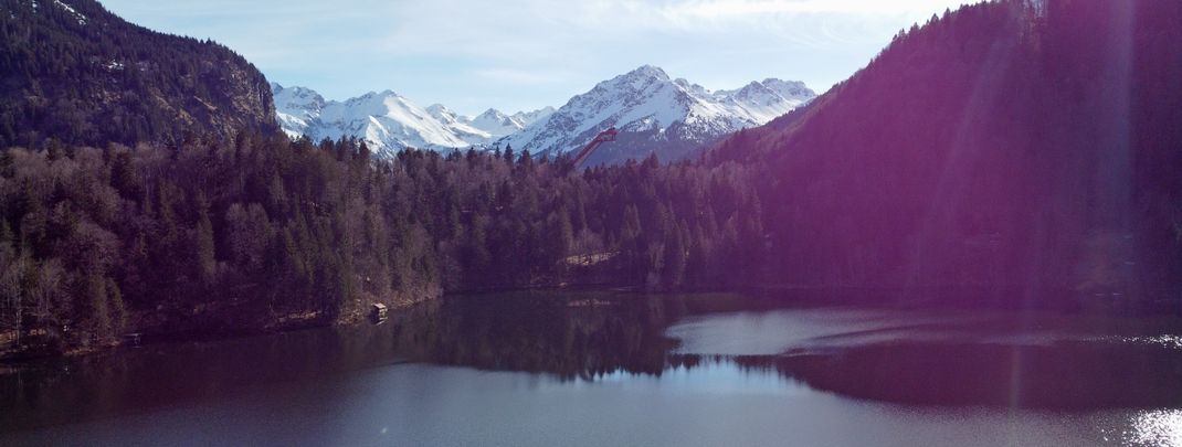 Der Freibergsee mit der Skiflugschanze im Hintergrund ist eines der Highlights auf der Wanderung.