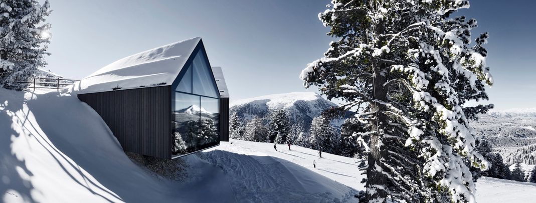 Die Berghütte Oberholz fügt sich mit ihren großen Fensterportalen einzigartig in die Eggentaler Bergwelt ein.