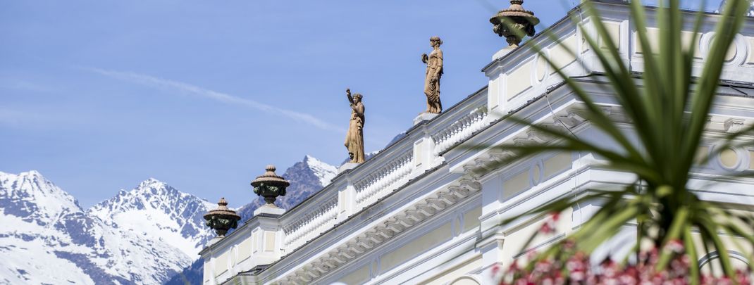 Meraner Land: Schneebedeckte Gipfel treffen auf grüne Palmen.