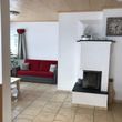 Wohnzimmer mit Couchecke und Holzofen