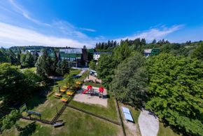 Außenansicht im Sommer mit Biergarten und Spielplatz