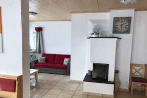 Wohnzimmer mit Couchecke und Holzofen