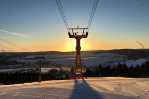 Sonnenaufgang über der schwarzen Piste