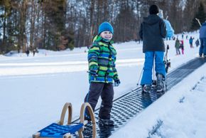 Schlittenfahrer kommen mit dem Zauberteppich bequem nach oben.