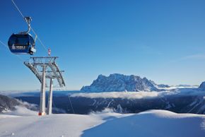 Die Grubigbahn II bringt die Wintersportler an den Fuße des Grubigsteins. Hier sieht man eine der Gondeln und die Zugspitze im Hintergrund.