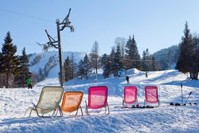 An einem langen Skitag kannst du dir eine Pause gönnen und die Sonne genießen.