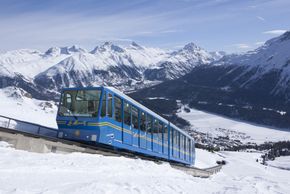 Mit der Standseilbahn Chantarella geht es hinauf während man den Blick über St- Moritz und den gefrorenen St. Moitzersee schweifen lassen kann.