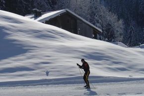 Die Loipe führt an traditionellen Häusern im Schweizer Ort Champéry vorbei.