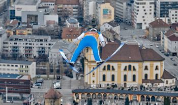 Über den Dächern von Innsbruck fliegen die Skispringer am Bergisel.