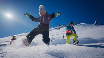 Winterfreude pur – Kinder toben im frischen Pulverschnee und genießen sonnige Wintertage im familienfreundlichen Tannheimer Tal.