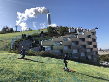 Auf grünen Matten führt die Piste vom Dach des Gebäudes hinunter ins Tal.