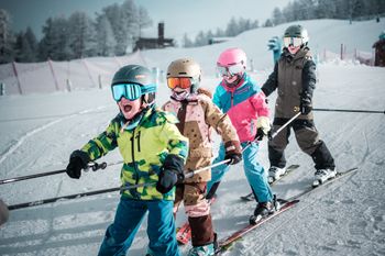 In Skikursen können Kinder das Skifahren lernen.