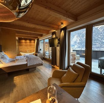 Die großen Zimmer sind in warmen Farben gehalten und bieten viel Tageslicht mit bodentiefen Fenstern.