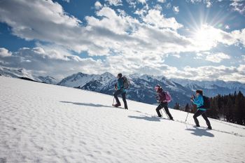 Auf Schneeschuhen entdeckst du bei traumhafter Aussicht durchs Winterwunderland.