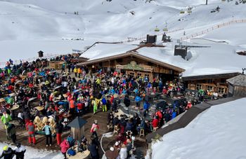 Die gut besuchte Sonnenterrasse der Hochalm zeigt, wie Après-Ski in den Alpen gelebt wird.