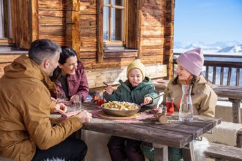 Auf den Sonnenterrassen der Hütten und Bergrestaurants genießt du leckere Tiroler Schmankerl bei bester Aussicht.