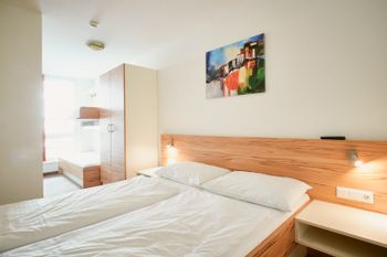 Das Schlafzimmer verfügt über ein Doppelbett und ein ausklappbares Etagenbett für 2 Personen, sowie ein Badezimmer mit Dusche und WC.